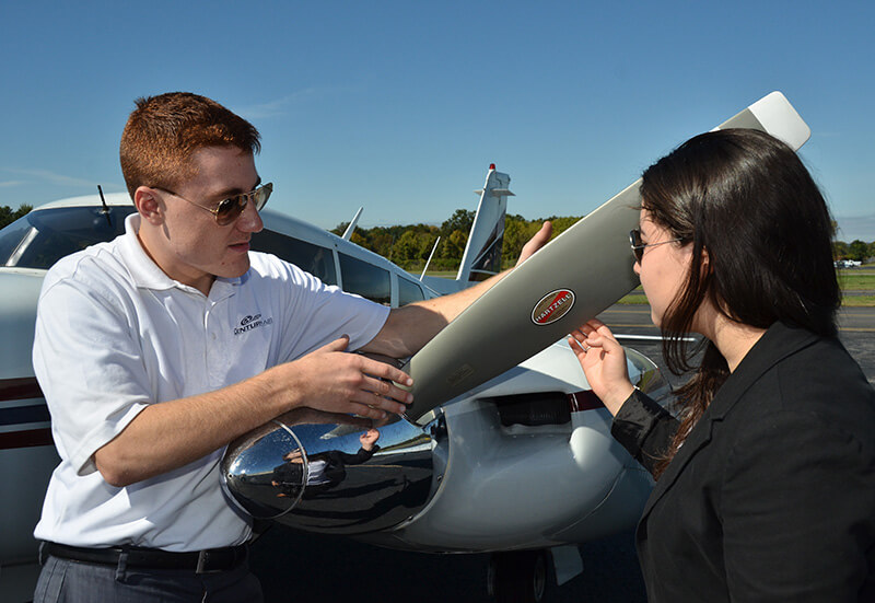Century Air flight instructor with student by propeller of airplane