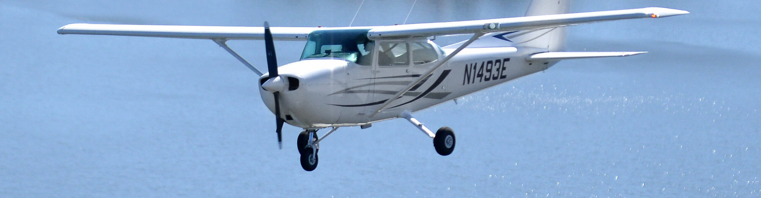 One of Century Air's aircraft flying over a lake in New Jersey