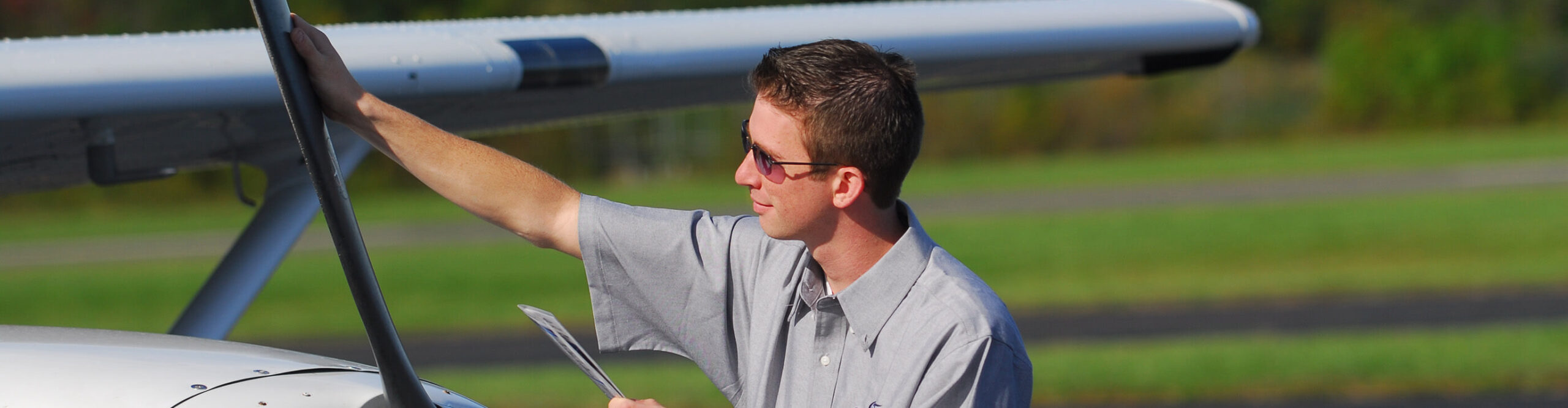 Flight student at Century Air Flight School checking airplane before flight